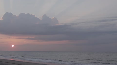 The sun is setting on the beach