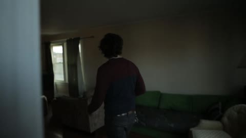 Man walking through a house with cup of coffee