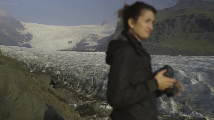 A woman takes photographs in a mountainous area