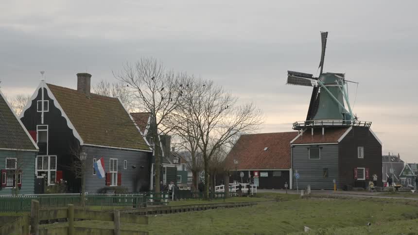 Quaint small town with a slow moving windmill atop a building