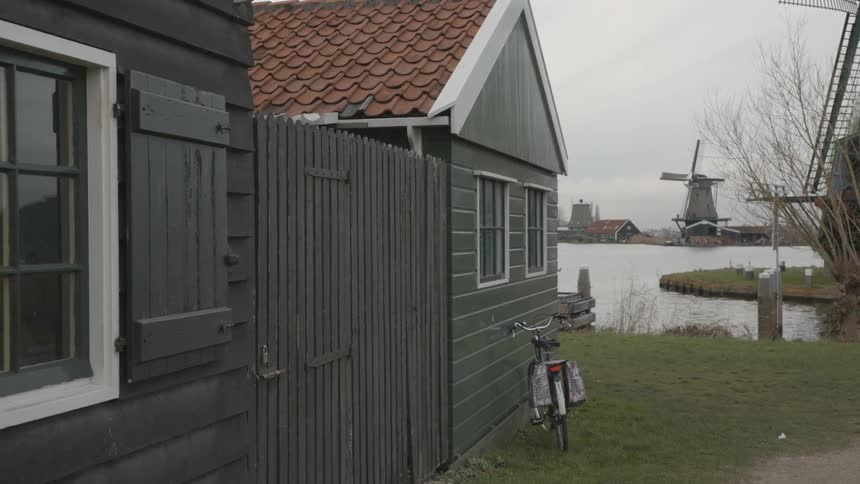 Bike rests against a house near a lake