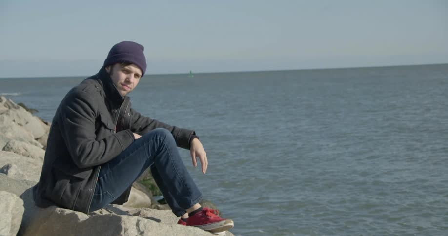 A man thinks next to the ocean