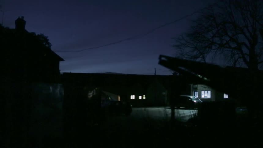 Lights shining across the street on a dark night