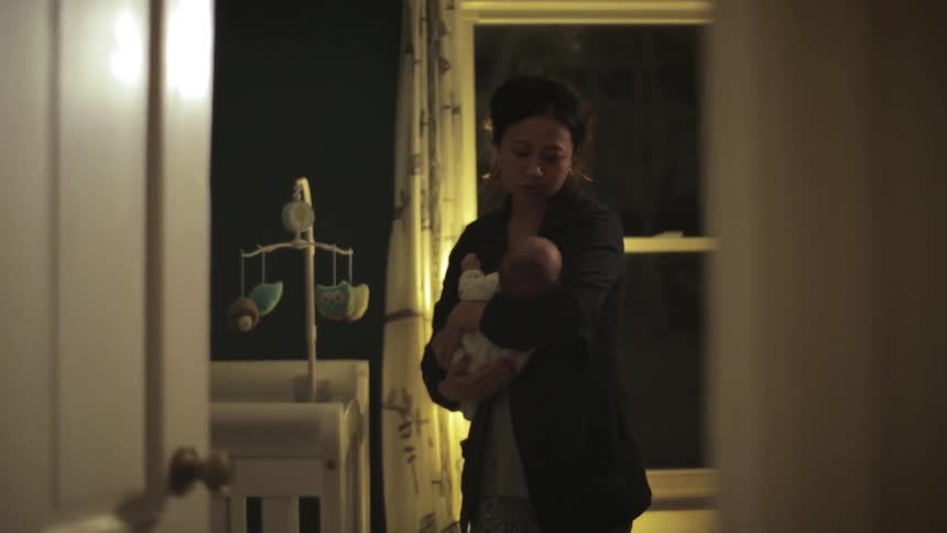 Woman standing and rocking a baby back and forth