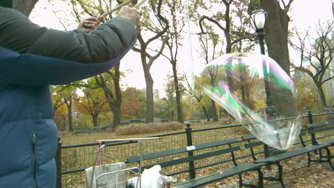 A person makes a large bubble