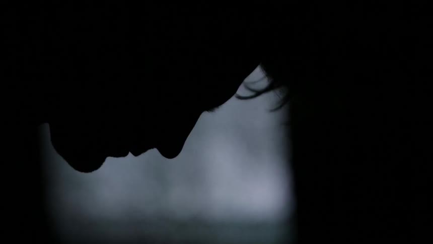 A silhouette of a sad man