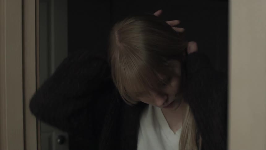 Woman stands at the entrance and ties her hair