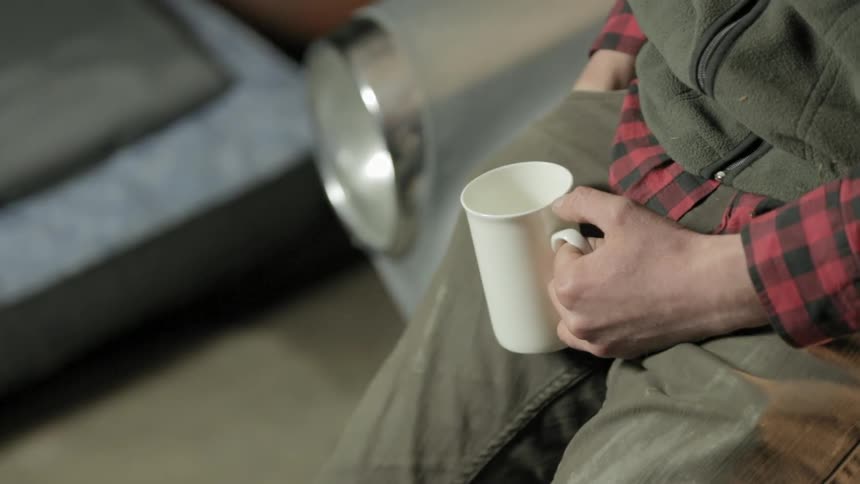 A person sitting holding a coffee mug
