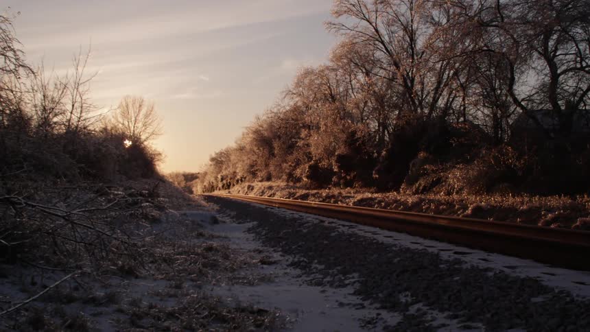 Train tracks in a remote area with snow on the ground