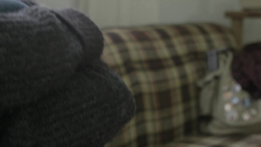 A fidgety, nervous looking woman sitting on a couch