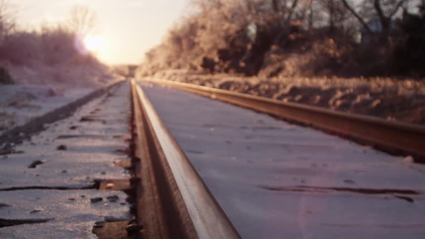 The sun shines on a railroad track