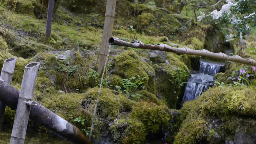 A spout fills with water while a stream flows