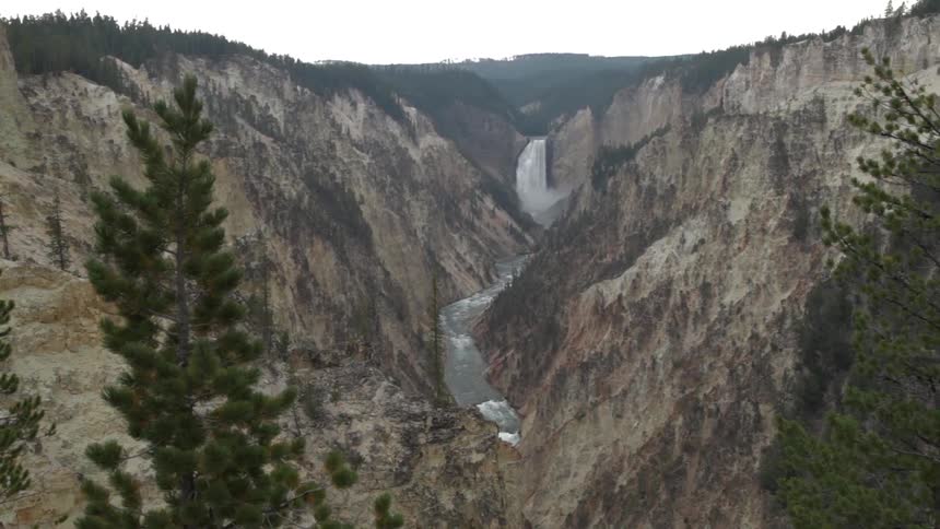 Wide view of a large waterfall flowing into a deep gorge
