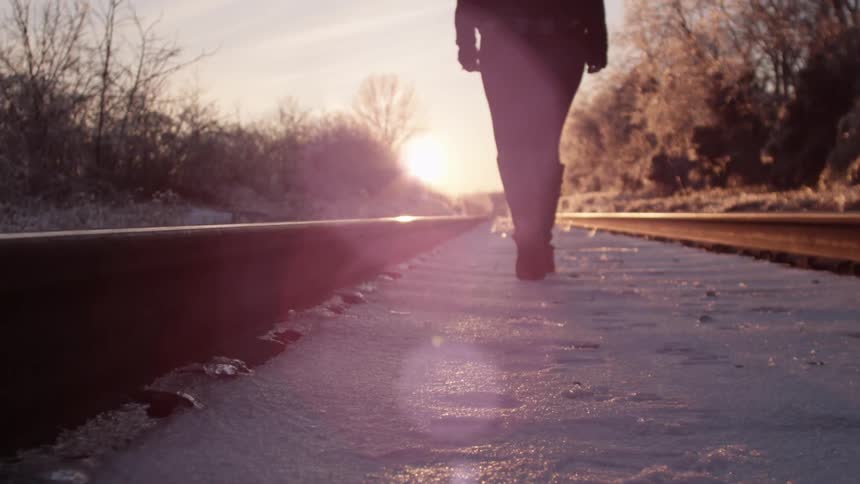 Woman walking next to the train tracks