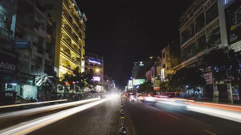 Lights from traffic driving up and down a street in a city at night