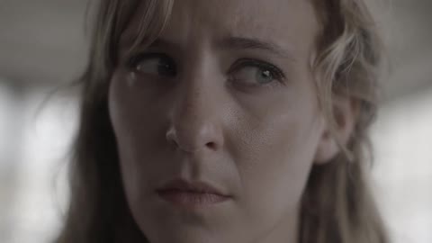 Closeup of a woman who warily watches the area around her