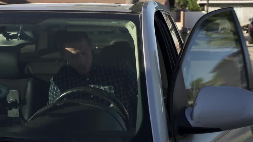 A man opens the door of his car and enters