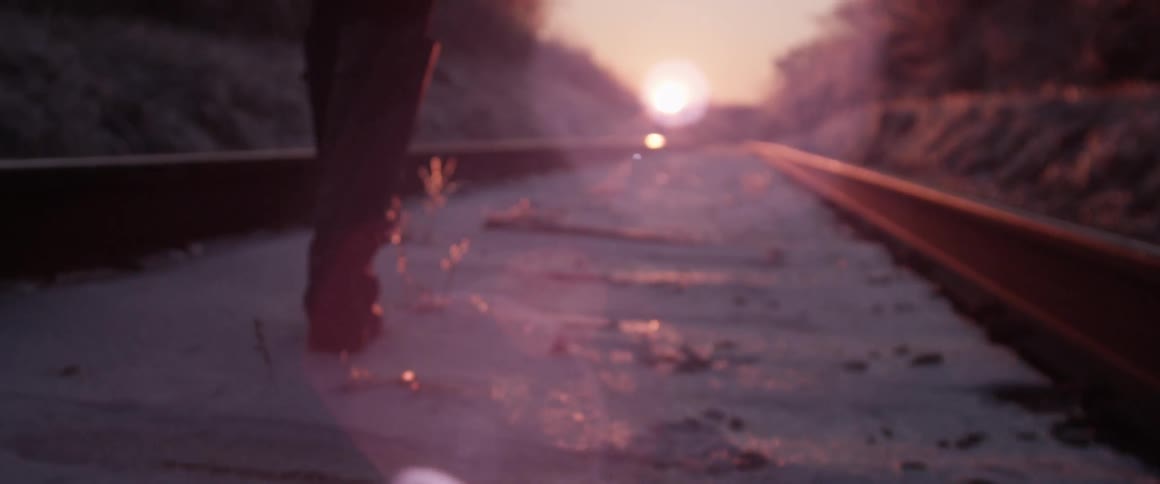 A person walking along the train tracks