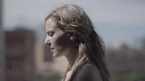 The sun shines on a woman in an urban area