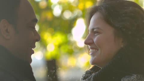 A man and woman smile and stare at each other