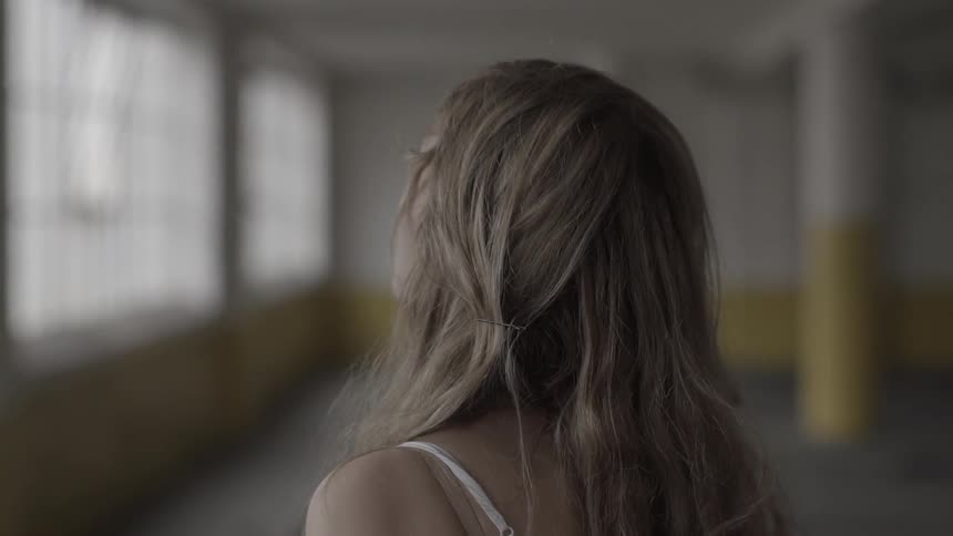 Nervous looking woman walks and looks around a room