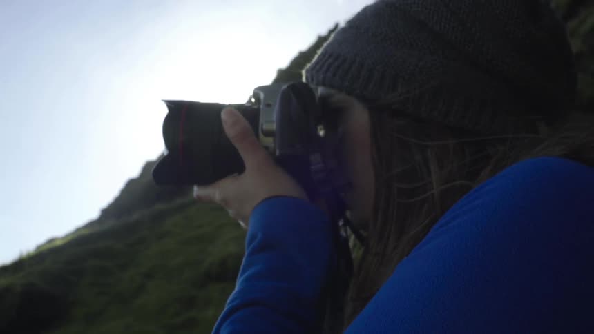 A hiker takes a photograph in the wilderness