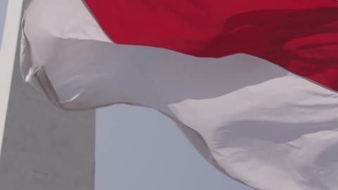 A red and white flag billows in the wind