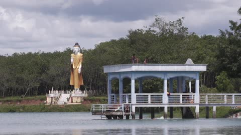Young boys jumping from a pier into a lake