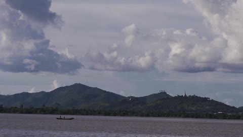 A scenery of a mountain and a boat in a lake