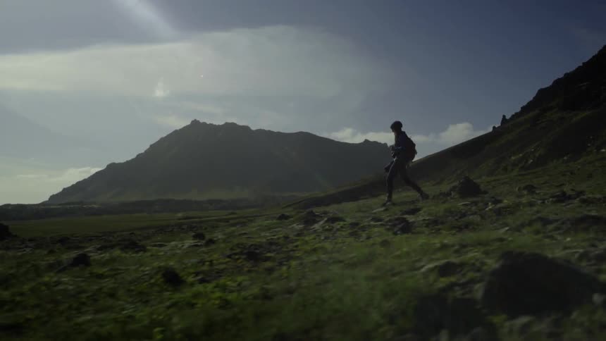 A hiker stops to take a photograph and then continues on