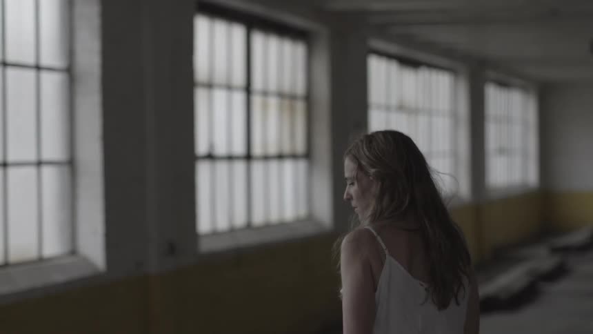 A woman walks by paned windows