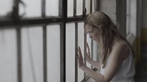 A woman looks out a window