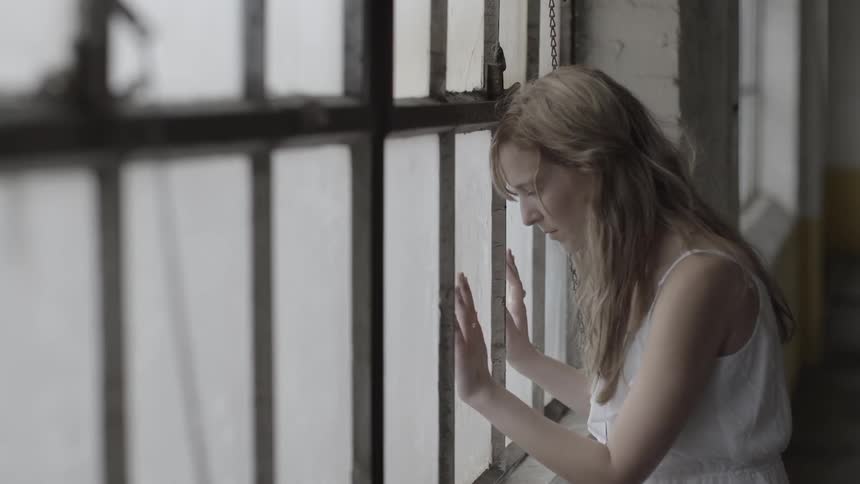 A woman looks out a window