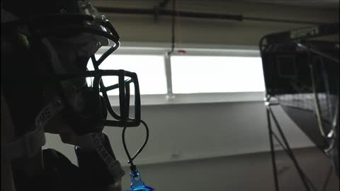 A boy places a football helmet on his head