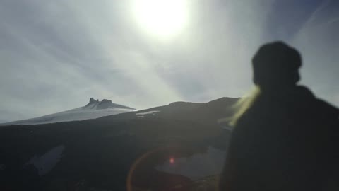 Person hiking towards a snow covered mountain