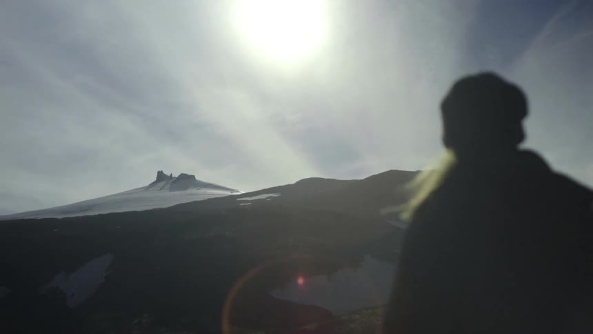 Person hiking towards a snow covered mountain