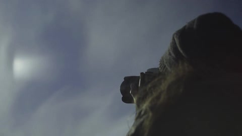 A woman photographs the mountains while the sun shines down brightly