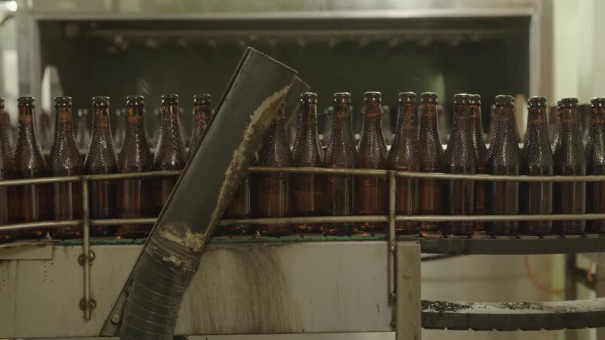 Brown glass bottles on a conveyor belt