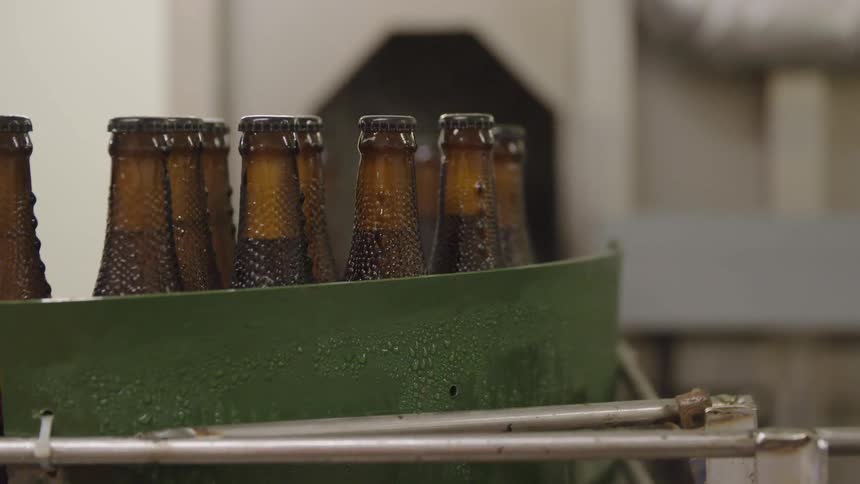 Brown glass bottles on a conveyor belt