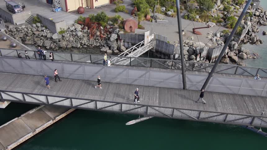 Pedestrians walk across a bridge