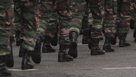 Soldiers legs and feet marching down a street