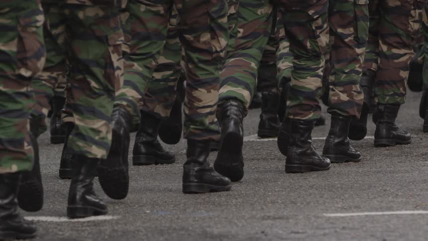 Soldiers legs and feet marching down a street