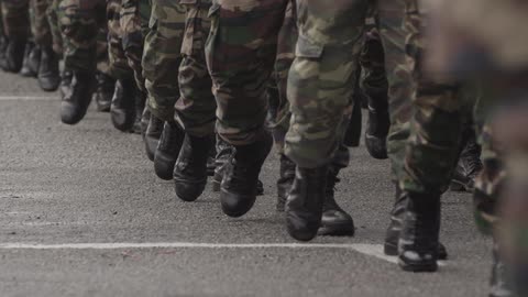 Many men marching in boots and army clothing