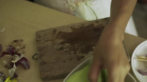 A woman cuts fruit on a cutting board