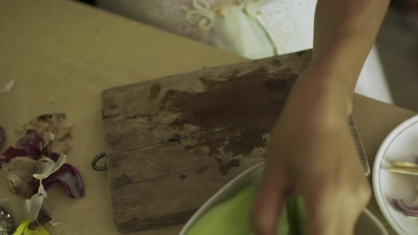 A woman cuts fruit on a cutting board