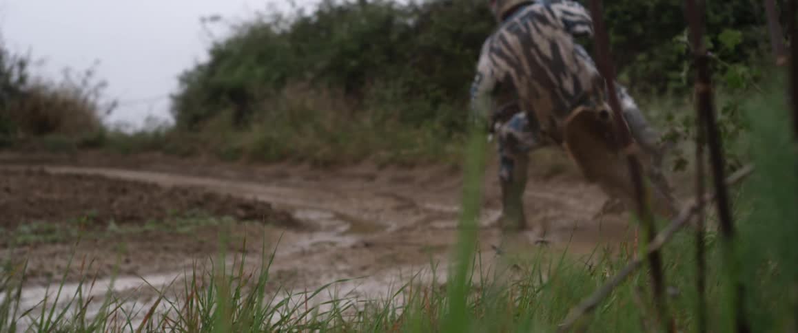 A person rides a dirt bike through mud