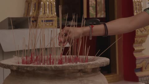 A person placing incense