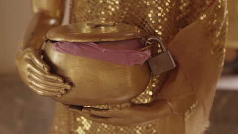A golden person and pot