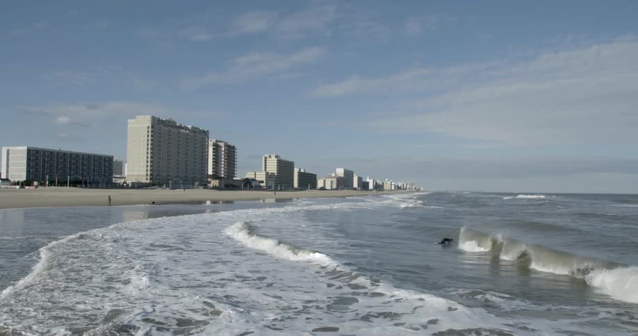 A long-shot view of a beach with tall hotels lining the shoreline