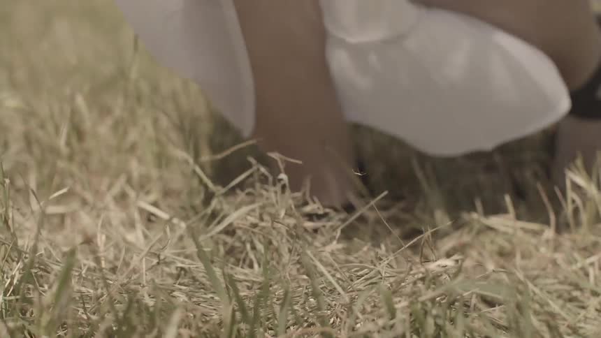A woman in a white dress running in a field
